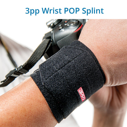 A person's wrist wearing a black 3pp Wrist POP Splint, designed for supporting the wrist and controlling pressure to alleviate pain from TFCC injuries and ulnar-sided wrist pain.