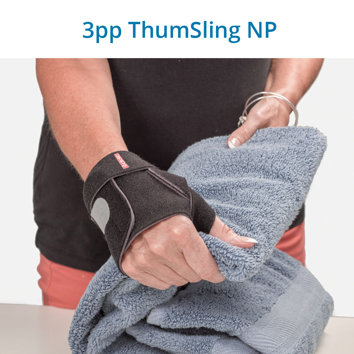 3pp ThumSling NP  thumb brace on a person’s hand, supporting the base of the thumb (CMC joint) while holding a blue towel, ideal for managing thumb arthritis.